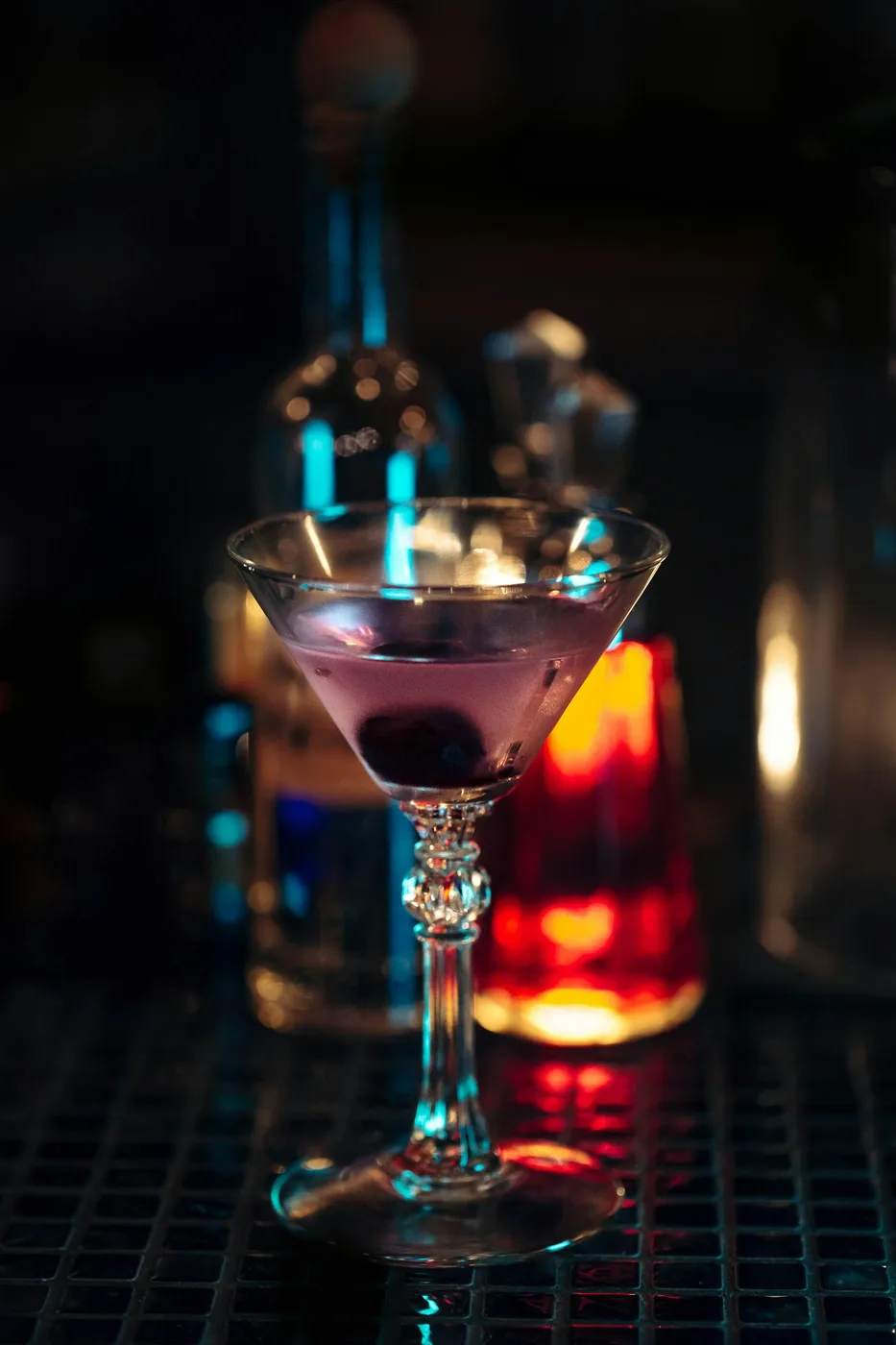 A cocktail glass on a dim bar counter; contextual photograph, not a photograph of The Ballpark Mojito