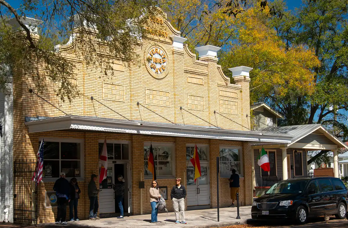 The yellow-brick former Ferlita Bakery building that now houses Ybor City Museum State Park, with visitors on the sidewalk