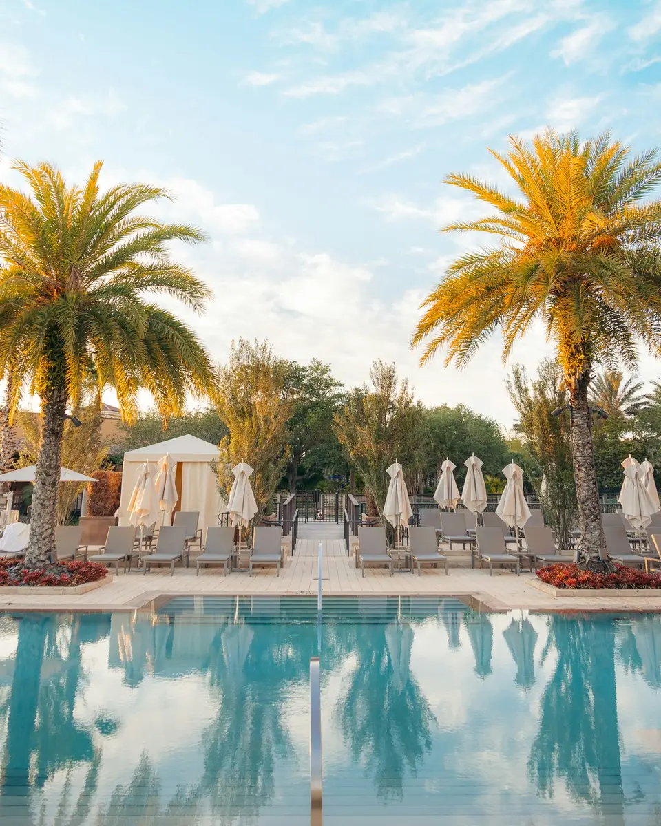 Palm trees and lounge chairs beside a resort pool in Orlando